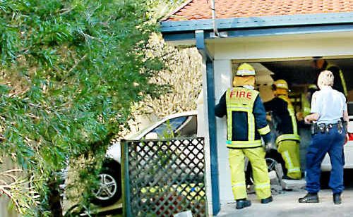 Emergency service crews work to free a car that crashed through the garage wall of a Toormina home yesterday. Emergency service crews work to free a car that crashed through the garage wall of a Toormina home yesterday.